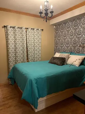 a bedroom with a bed with a blue comforter at The HI-Mark House - Hot tub,AC,Pool table, Pool May2026 in Sicamous