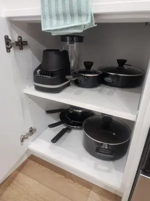 a kitchen shelf with pots and pans on it at Cozy 2 BR Suite Self check-in I Free Park Pass in Calgary