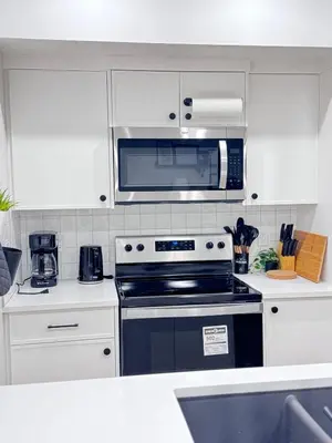 a kitchen with a stove and a microwave at Cozy 2 BR Suite Self check-in I Free Park Pass in Calgary