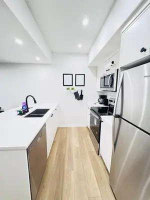 a kitchen with white counters and a stainless steel refrigerator at Cozy 2 BR Suite Self check-in I Free Park Pass in Calgary