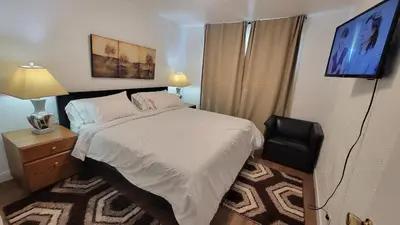 a small bedroom with a bed and a television at 3 Bedroom House Near Airport and Downtown in Calgary