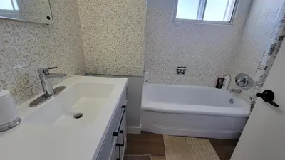 a bathroom with a sink and a tub and a toilet at 3 Bedroom House Near Airport and Downtown in Calgary
