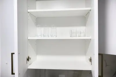 a white cupboard with glasses on it at Apartment In Calgary Near Airport in Calgary
