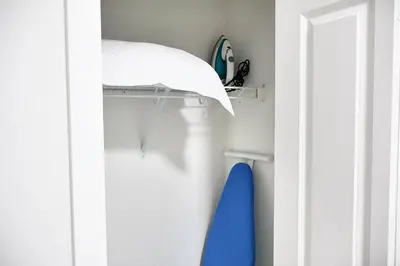 a closet with a white door and a blue surfboard at Apartment In Calgary Near Airport in Calgary