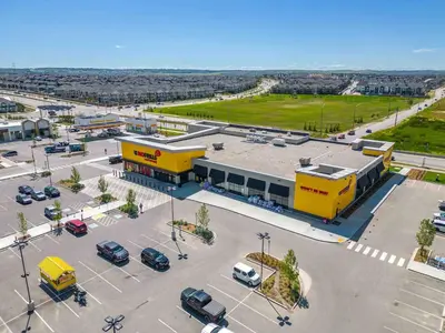 an empty parking lot in front of a yellow building at Apartment In Calgary Near Airport in Calgary