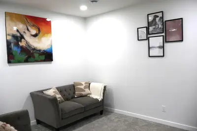 a living room with a couch and a painting on the wall at Apartment In Calgary Near Airport in Calgary