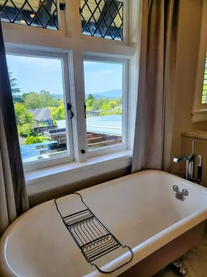 a bath tub in a bathroom with a window at Shaughnessy Heritage Manor on Vancouver's Westside free housekeeping optional in Vancouver