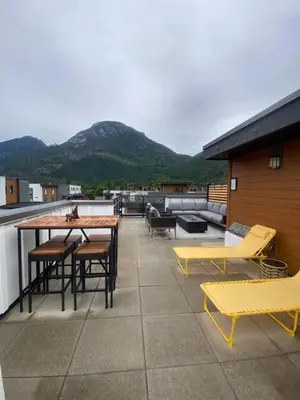 a patio with yellow tables and chairs on a roof at Stylish Three Bedroom Townhome in Squamish