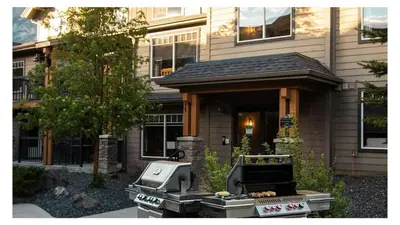 a barbecue grill in front of a house at Best 2BR Canmore Stay, Banff, Wifi & Free Parking Incl in Dead Man's Flats