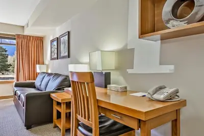 a living room with a desk and a telephone at Best 2BR Canmore Stay, Banff, Wifi & Free Parking Incl in Dead Man's Flats