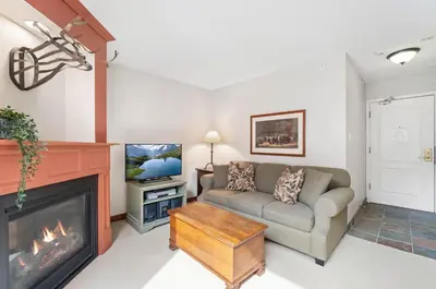 a living room with a couch and a fireplace at 1BR and Sofabed in Marquise, Near Ski Hill, Fireplace, Hot Tub and Sauna, Gym Access in Whistler