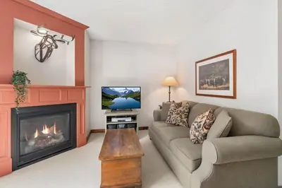 a living room with a couch and a fireplace at 1BR and Sofabed in Marquise, Near Ski Hill, Fireplace, Hot Tub and Sauna, Gym Access in Whistler