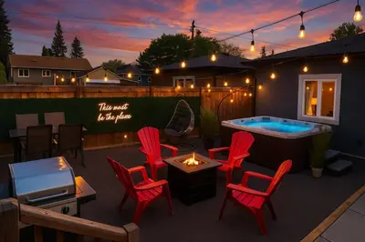 a patio with a hot tub and red chairs at Summer Haven - HotTub - FireTable - KingBed - BBQ - Sleeps8 in Edmonton