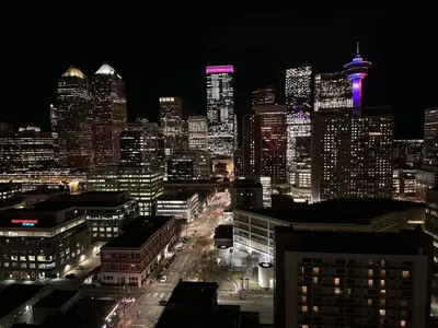a view of a city at night with purple lights at Urbanest - Spectacular Views & Amenities Parking in Calgary