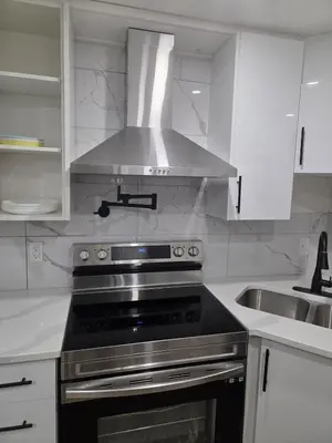 a kitchen with a stainless steel stove and a sink at Exclusive Suite in Edmonton in Edmonton