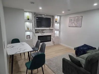 a living room with a table and chairs and a television at Exclusive Suite in Edmonton in Edmonton