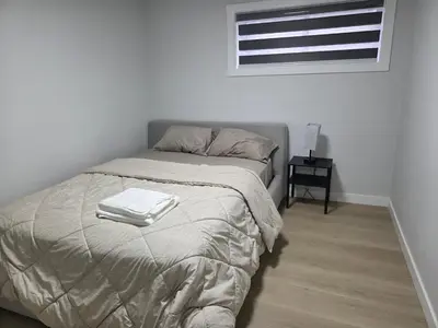 a bedroom with a bed with two towels on it at Exclusive Suite in Edmonton in Edmonton