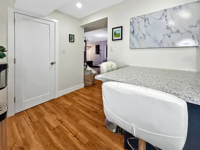 a bedroom with a white bed and a white chair at Renovated Suite in WL, 5 Min to Downtown, All New Appliances, Self Check-In in Williams Lake