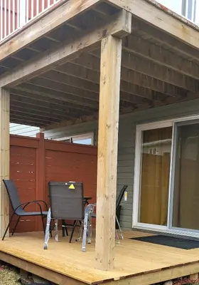 a patio with two chairs and a table on a deck at Spacious Basement Suite NW Calgary- 1bedroom 2 guest maximum in Calgary