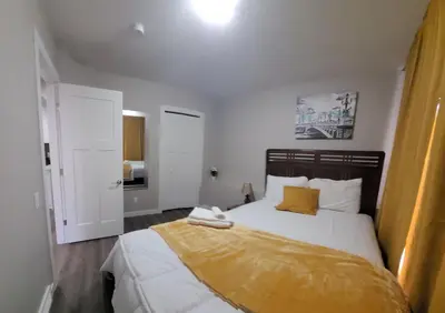 a bedroom with a bed with a yellow blanket on it at Spacious Basement Suite NW Calgary- 1bedroom 2 guest maximum in Calgary
