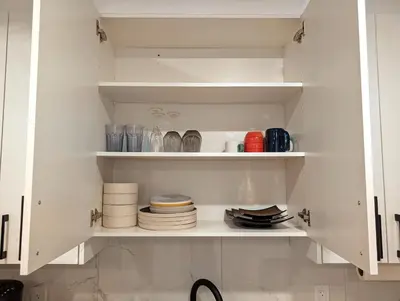 a kitchen cabinet filled with plates and dishes at Luxury Guest Suite in Calgary in Calgary
