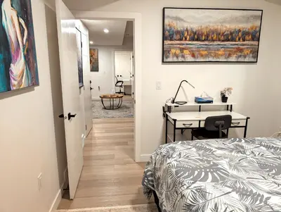 a bedroom with a bed and a desk and a table at Luxury Guest Suite in Calgary in Calgary