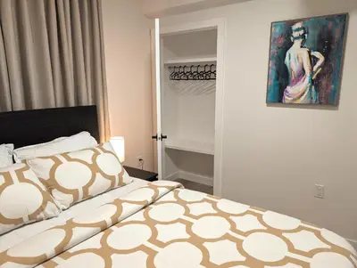 a bedroom with a bed and a painting on the wall at Luxury Guest Suite in Calgary in Calgary