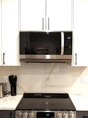 a microwave above a stove in a kitchen at Luxury Guest Suite in Calgary in Calgary