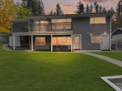 a house with a balcony and a lawn at Private Studio - 5 Min to DT - Self Check-In - 75 Inch TV in Williams Lake