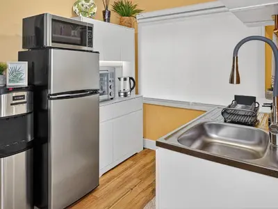 a kitchen with a stainless steel refrigerator and a sink at Private Studio - 5 Min to DT - Self Check-In - 75 Inch TV in Williams Lake