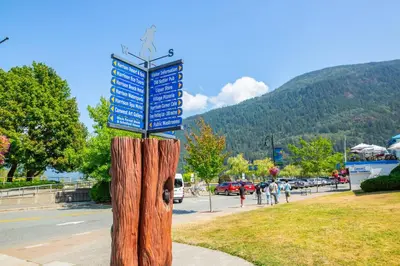 a sign on top of a wooden tree stump at The Driftwalk Walkable to Beach in Harrison Hot Springs