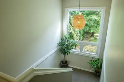 a staircase with a window and a potted plant at Studio w Balcony with Smart TV and 2 Min Walk to Lake in Harrison Hot Springs