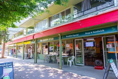 a building with tables and chairs on a street at Studio w Balcony with Smart TV and 2 Min Walk to Lake in Harrison Hot Springs