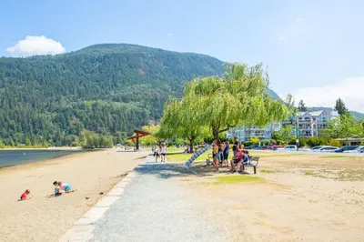 a group of people sitting on a beach at RiversTail Retreat Pet-Friendly and Steps to The Lake in Harrison Hot Springs