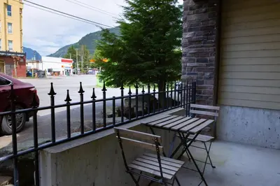 two chairs and a table next to a fence at RiversTail Retreat Pet-Friendly and Steps to The Lake in Harrison Hot Springs
