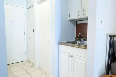 a kitchen with white cabinets and a sink at The Flats at Cedar Springs with Full Kitchen and Steps to Lake in Harrison Hot Springs