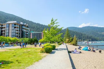 a group of people on a beach near the water at The Flats at Cedar Springs with Full Kitchen and Steps to Lake in Harrison Hot Springs