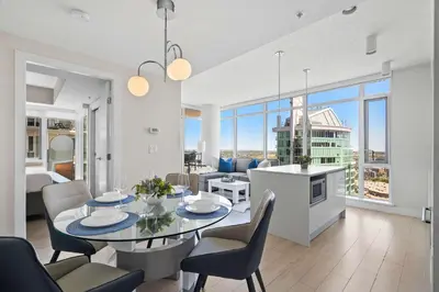 a kitchen and living room with a table and chairs at The Getaway Next to Stampede 2BR Suite Downtown in Calgary