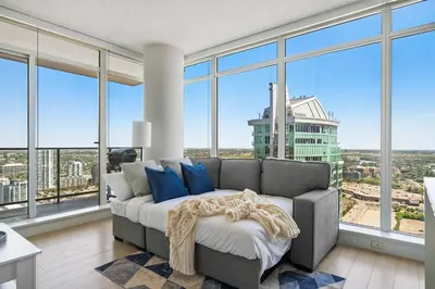 a living room with a couch and large windows at The Getaway Next to Stampede 2BR Suite Downtown in Calgary