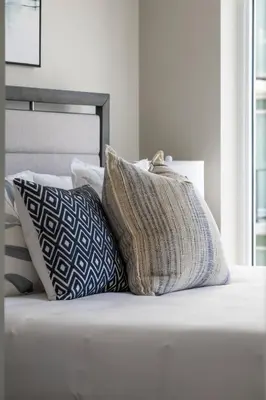 a pile of pillows sitting on top of a bed at The Getaway Next to Stampede 2BR Suite Downtown in Calgary