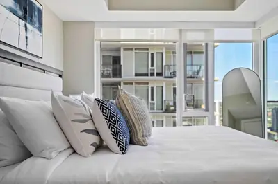a bedroom with a white bed with pillows at The Getaway Next to Stampede 2BR Suite Downtown in Calgary