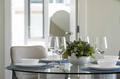 a dining room table with glasses and a vase of flowers at The Getaway Next to Stampede 2BR Suite Downtown in Calgary