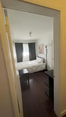 a bedroom with a bed and a desk in it at Hotel Room 2 in Coquitlam
