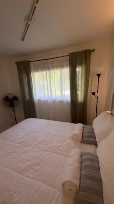 a bedroom with a large white bed with a window at Hotel Room 2 in Coquitlam