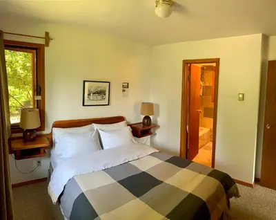 a bedroom with a bed and two lamps and a window at Wing Creek Resort in Kaslo