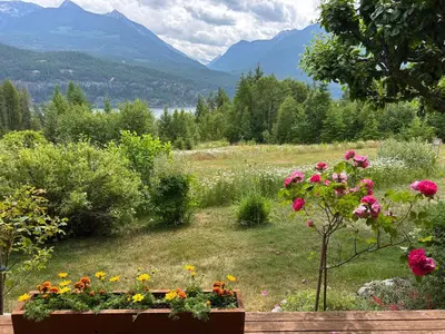 a garden with flowers and mountains in the background at Wing Creek Resort in Kaslo