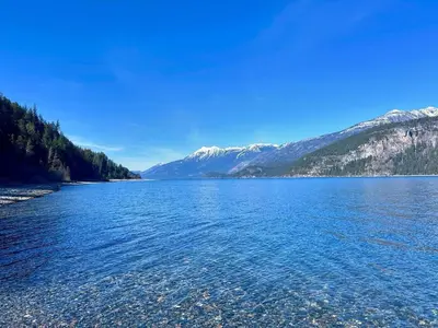 a view of a lake with mountains in the background at Wing Creek Resort in Kaslo