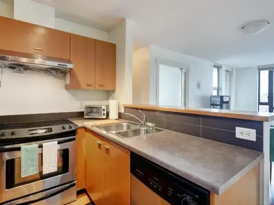 a kitchen with a sink and a stove at Astoria Escape - Bright condo with work desk by Victoria Prime! in Victoria