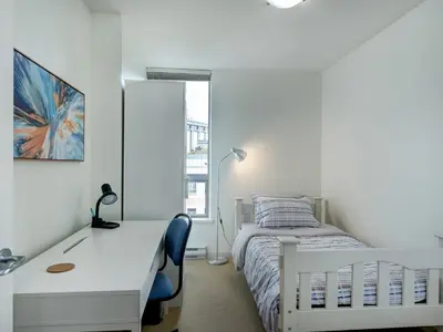 a white bedroom with a bed and a desk and a window at Astoria Escape - Bright condo with work desk by Victoria Prime! in Victoria