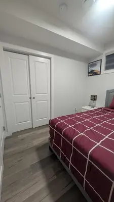 a bedroom with a bed and two white doors at Cozy Escape Guest Suite in Edmonton